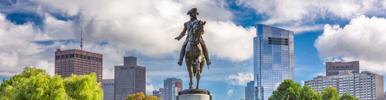 Boston Public Garden with Statue of Paul Revere in foreground and skyline in background
