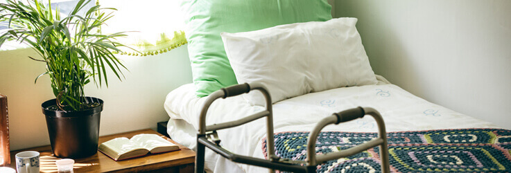 Bed with walker next to it in nursing home